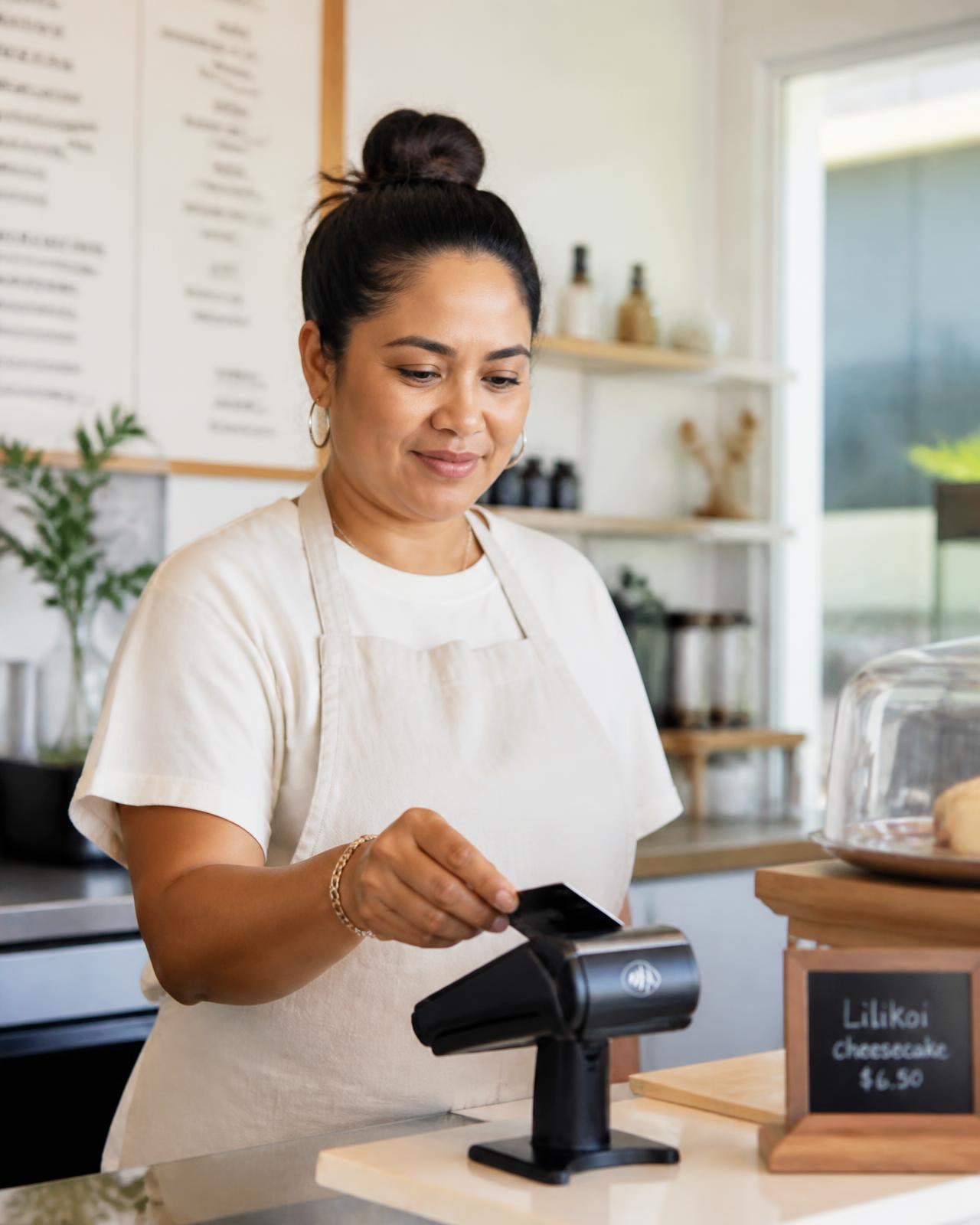 Hawaii café owner accepting a contactless card payment on a modern terminal